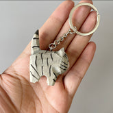 Black stripe gray cat keychain held in hand for size reference.